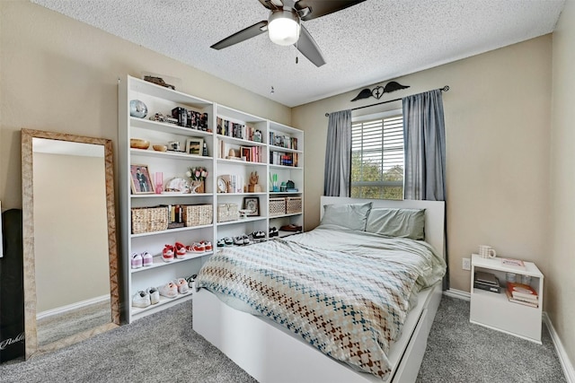 carpeted bedroom featuring a textured ceiling, baseboards, and a ceiling fan