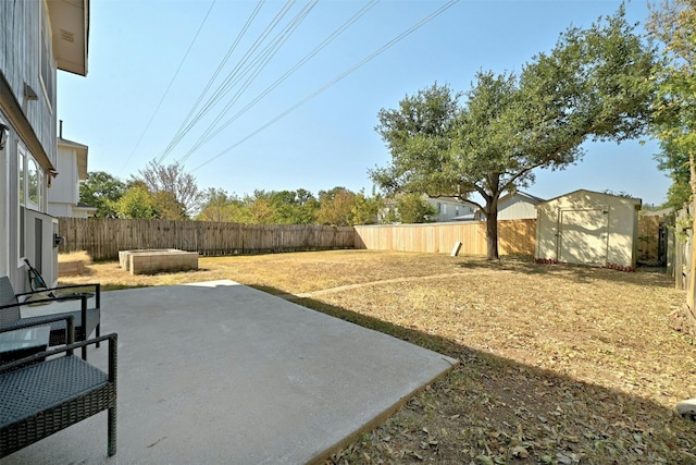 view of yard with a fenced backyard, a patio, an outdoor structure, and a shed