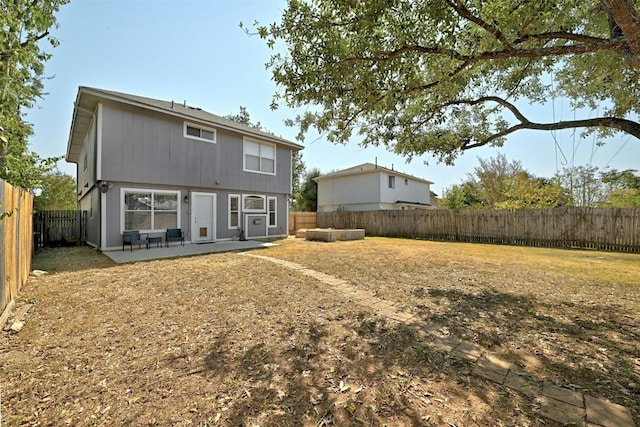 rear view of property featuring a patio and a fenced backyard