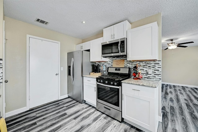 kitchen featuring tasteful backsplash, visible vents, white cabinets, and appliances with stainless steel finishes