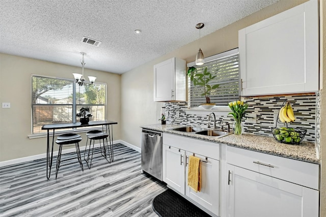 kitchen featuring visible vents, white cabinetry, an inviting chandelier, a sink, and dishwasher