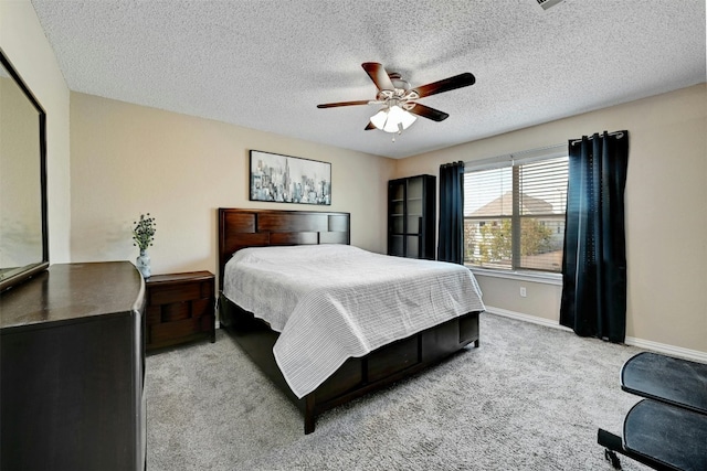 bedroom featuring baseboards, a textured ceiling, ceiling fan, and carpet flooring