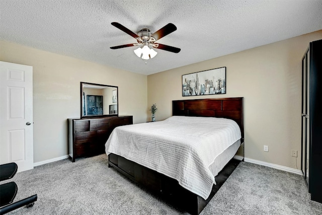 carpeted bedroom featuring a textured ceiling, baseboards, and a ceiling fan