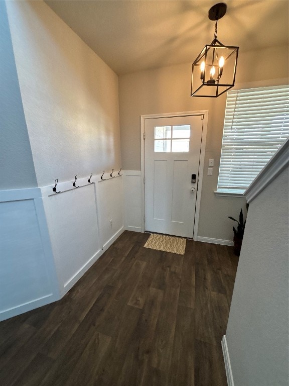 foyer featuring an inviting chandelier and dark hardwood / wood-style flooring