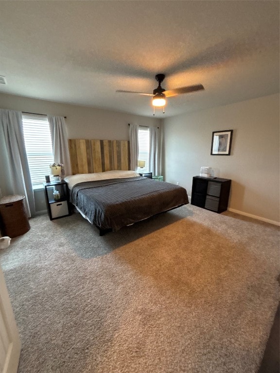 bedroom with ceiling fan, carpet, and a textured ceiling