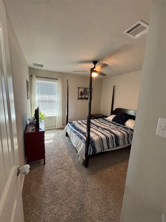 carpeted bedroom featuring a textured ceiling and ceiling fan