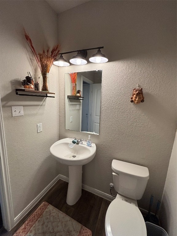 bathroom with hardwood / wood-style floors and toilet