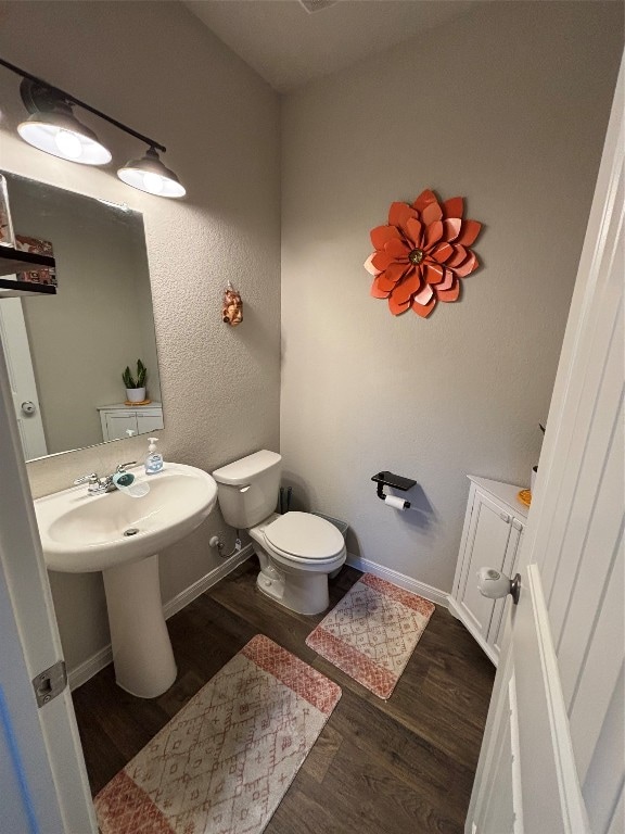 bathroom featuring wood-type flooring and toilet