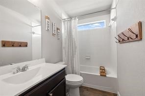 full bathroom featuring vanity, shower / bath combo with shower curtain, and toilet