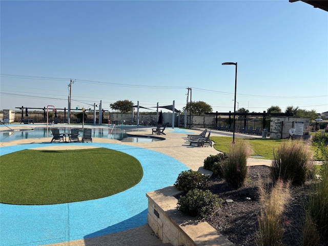 view of community with a pool, a lawn, and a patio area