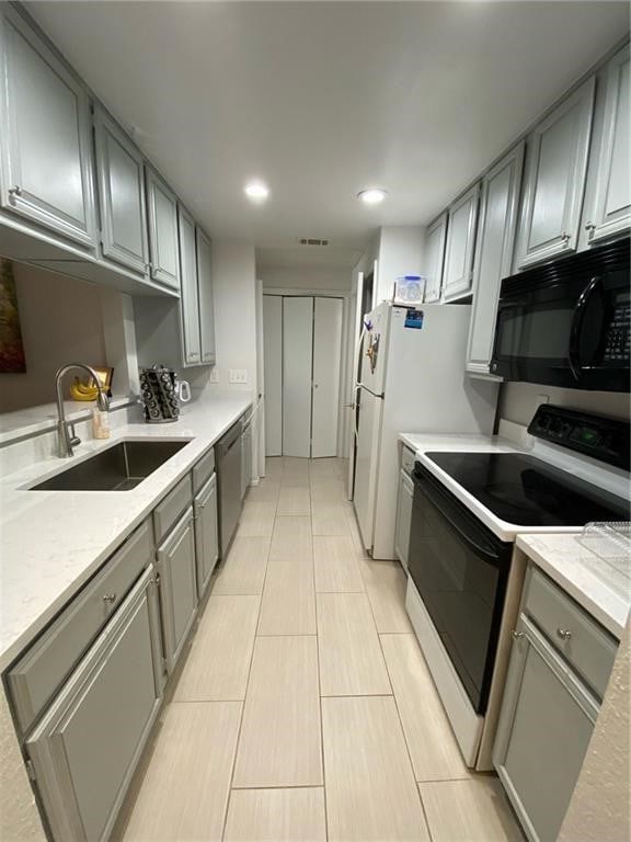 kitchen with light tile patterned flooring, sink, stainless steel dishwasher, gray cabinetry, and white electric stove