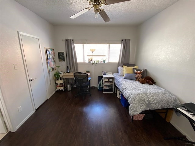 bedroom with a textured ceiling, ceiling fan, and dark hardwood / wood-style flooring