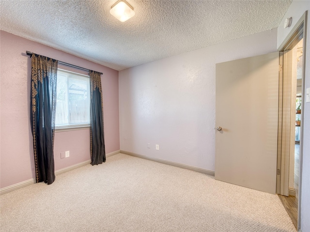 carpeted empty room with a textured ceiling