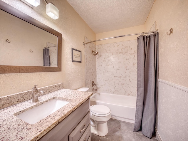 full bathroom featuring vanity, toilet, tile patterned floors, a textured ceiling, and shower / bath combo with shower curtain