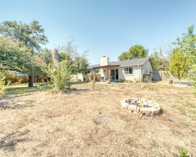 rear view of property with an outdoor fire pit