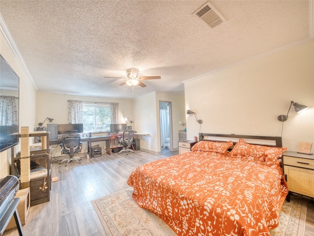 bedroom with a textured ceiling, light hardwood / wood-style flooring, ornamental molding, and ceiling fan