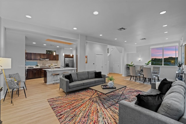 living room featuring sink and light hardwood / wood-style floors