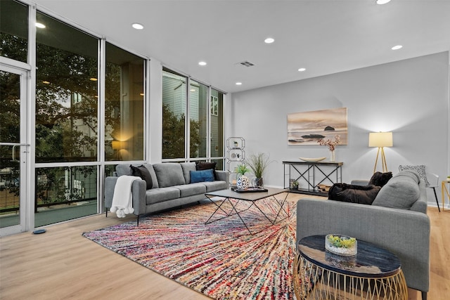 living room featuring light wood-type flooring and floor to ceiling windows