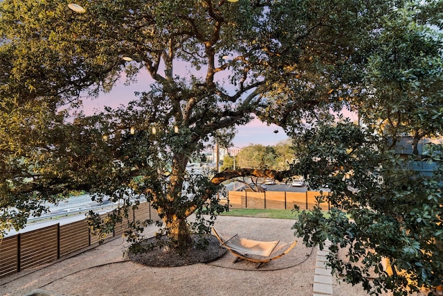 yard at dusk featuring a patio area