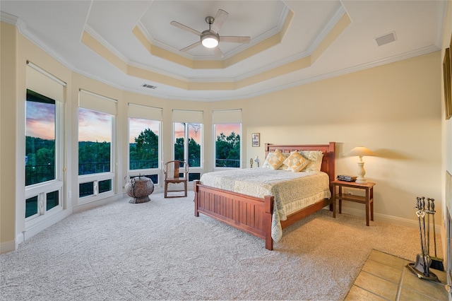 bedroom featuring a raised ceiling, crown molding, visible vents, and carpet floors