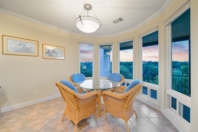 dining space featuring crown molding and light tile patterned flooring