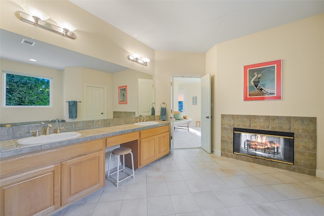 bathroom featuring tile patterned floors, vanity, and a tiled fireplace