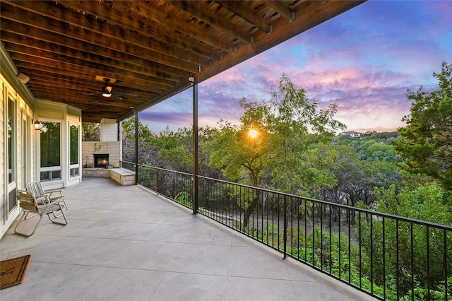 patio terrace at dusk with an outdoor stone fireplace