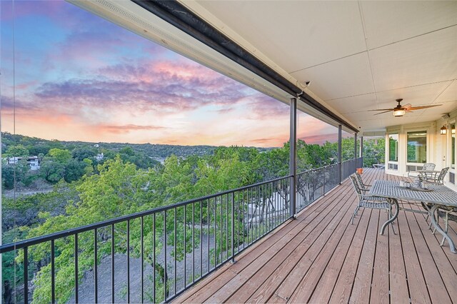 deck at dusk featuring ceiling fan