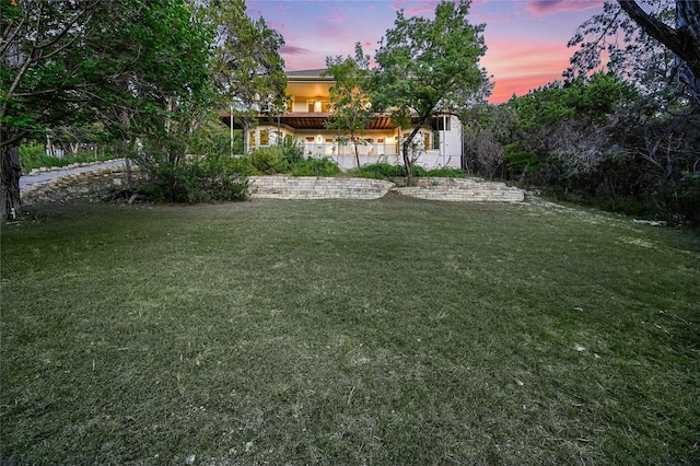 yard at dusk featuring a patio