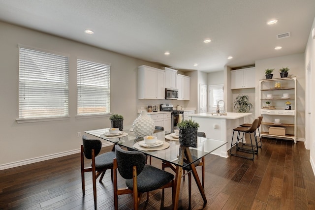 dining area with sink and dark wood-type flooring