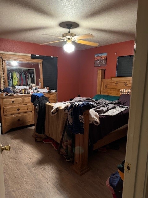 bedroom featuring wood-type flooring, a textured ceiling, and ceiling fan