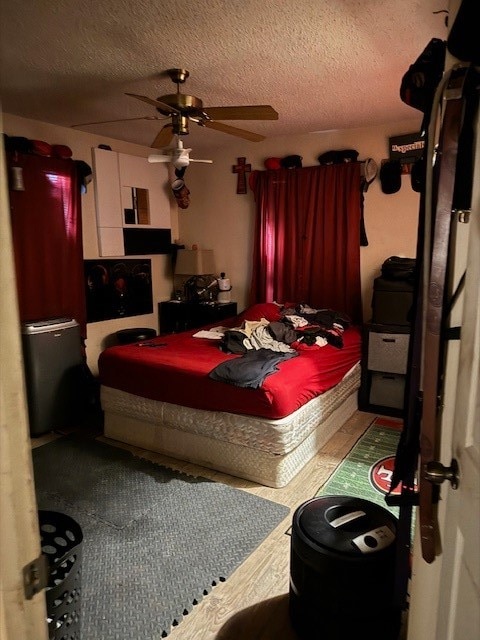 bedroom with ceiling fan and a textured ceiling