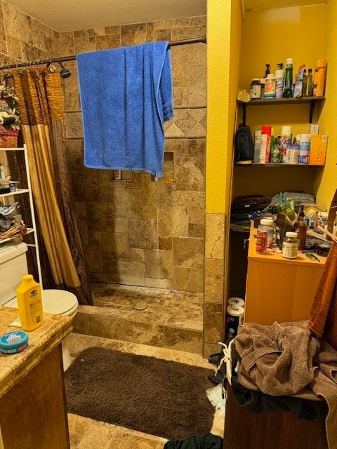 bathroom featuring toilet, walk in shower, and a textured ceiling