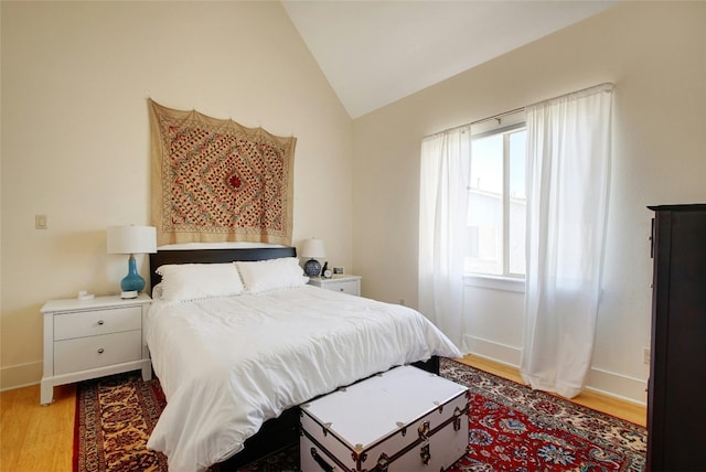 bedroom with vaulted ceiling and light wood-type flooring