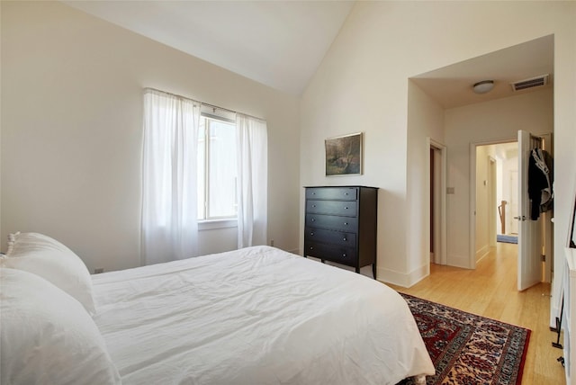 bedroom featuring vaulted ceiling and light wood-type flooring