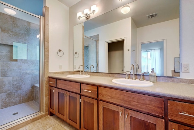 bathroom with vanity, a shower with shower door, and tile patterned floors