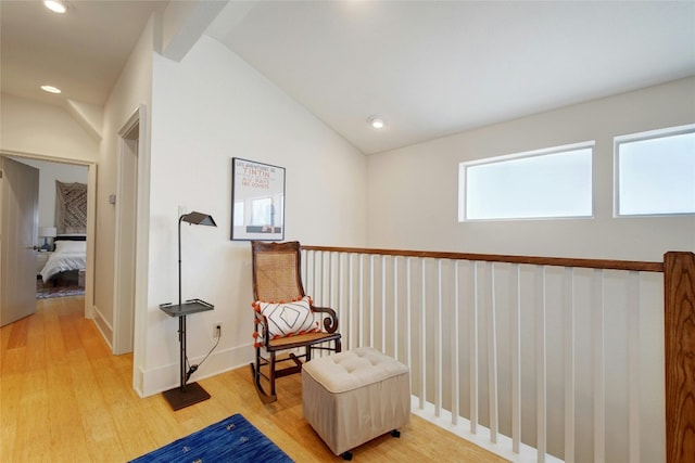 living area with hardwood / wood-style flooring and vaulted ceiling