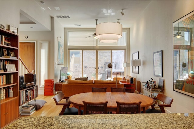 dining space with light wood-type flooring and ceiling fan