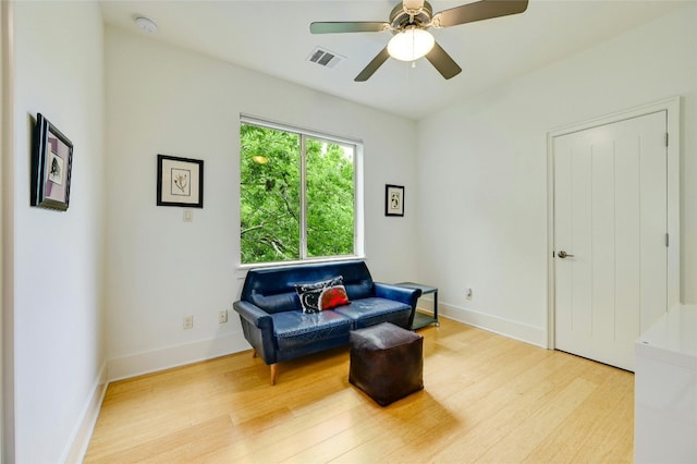 sitting room with light wood-type flooring and ceiling fan