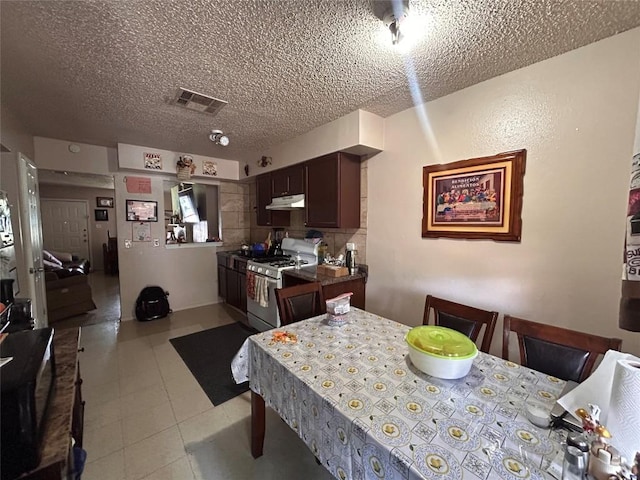 kitchen featuring a textured ceiling, dark brown cabinets, and white range with gas stovetop