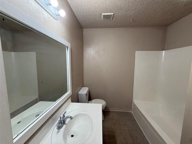 bathroom featuring vanity, a textured ceiling, tile patterned floors, and toilet