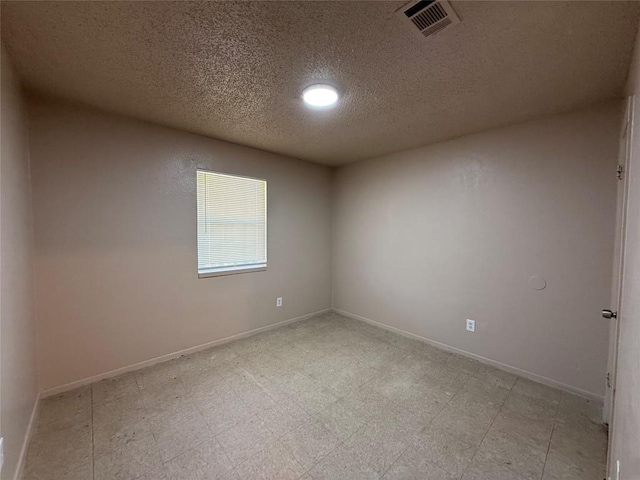 unfurnished room with a textured ceiling