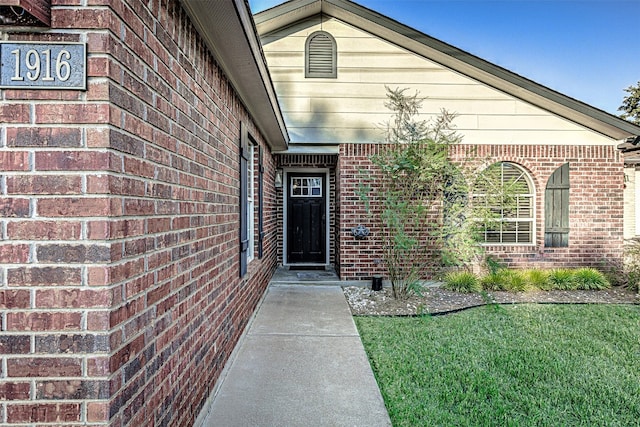 view of exterior entry featuring a yard