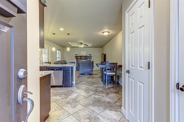 kitchen featuring ceiling fan, light stone counters, kitchen peninsula, decorative light fixtures, and dishwasher