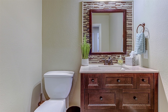 bathroom with vanity, decorative backsplash, and toilet