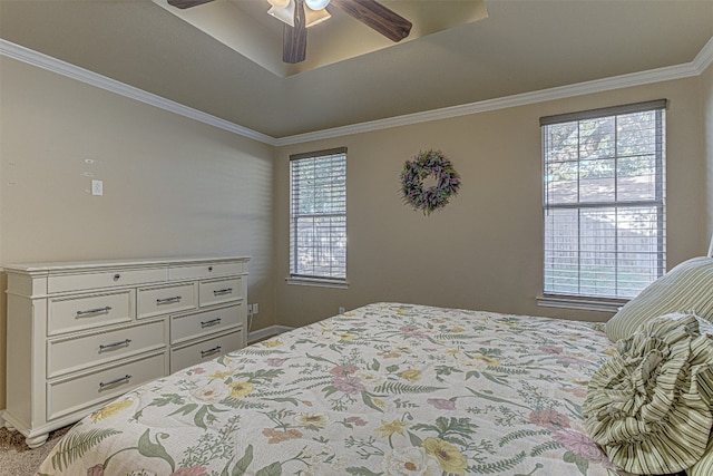 bedroom featuring ornamental molding, ceiling fan, a tray ceiling, and carpet