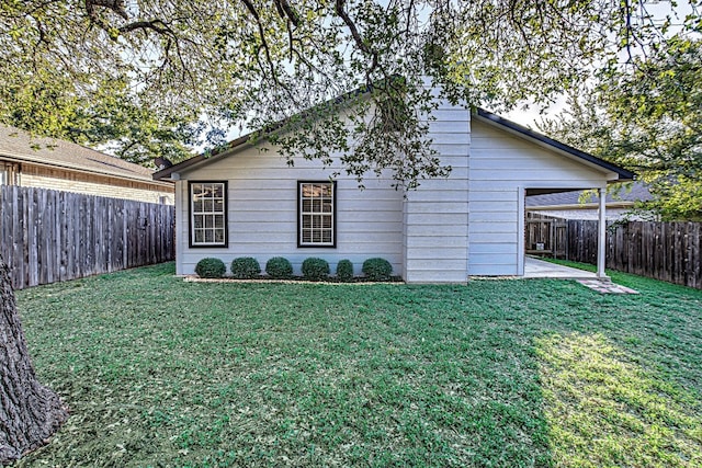 view of side of home featuring a yard and a patio