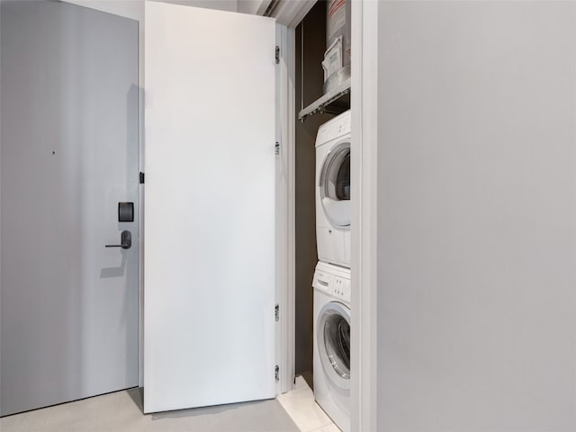 clothes washing area with stacked washer / dryer