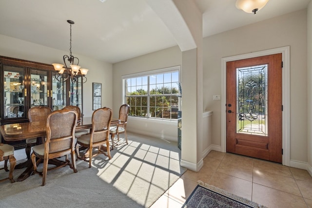 dining area with a notable chandelier and light tile patterned floors