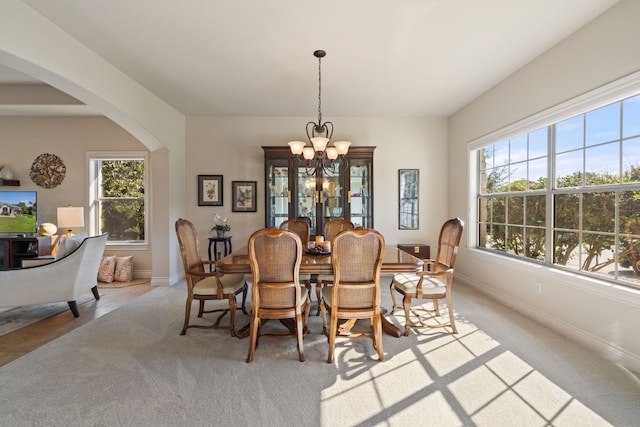 dining room featuring light colored carpet and a chandelier